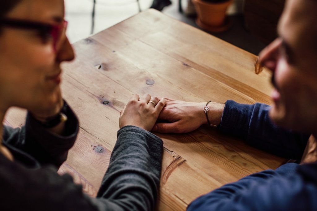 a man and a woman looking at a wooden table